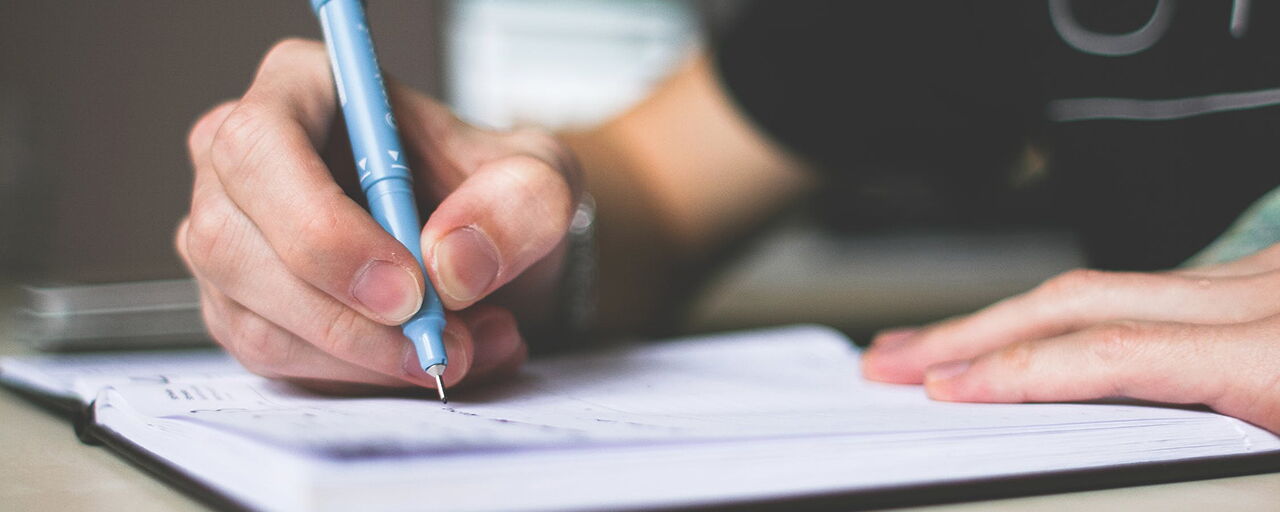 Person mit Stift beim Schreiben