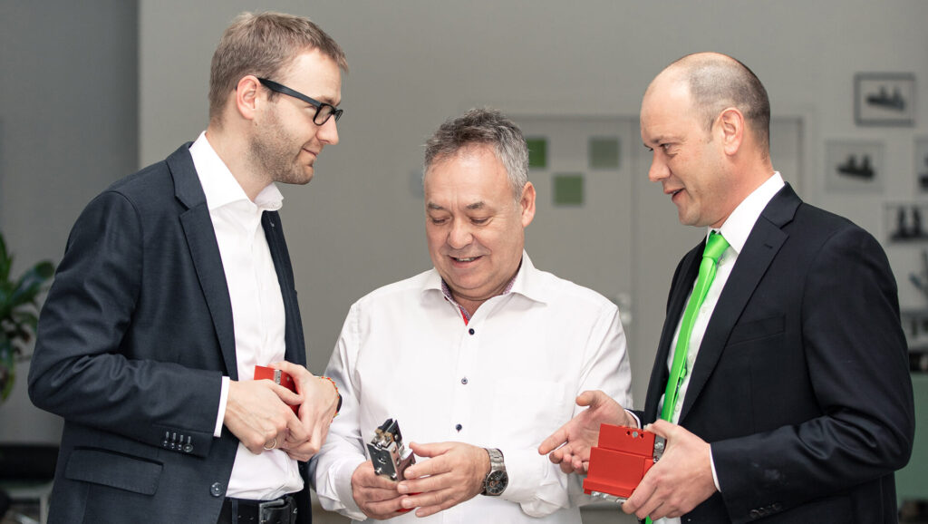 URBAN Maschinenbau - Urban employees Michael Walther, Fred Karsten Karl, and Andreas Pauls with workpieces